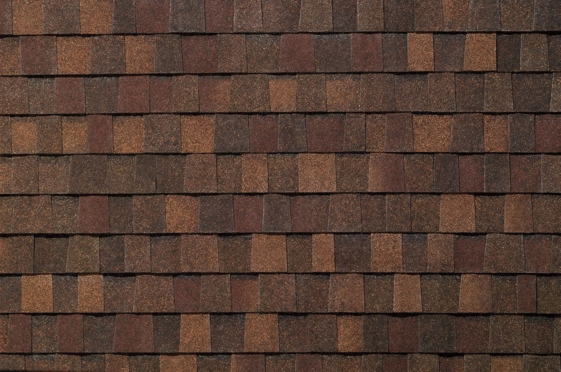 A close up of a roof with brown shingles