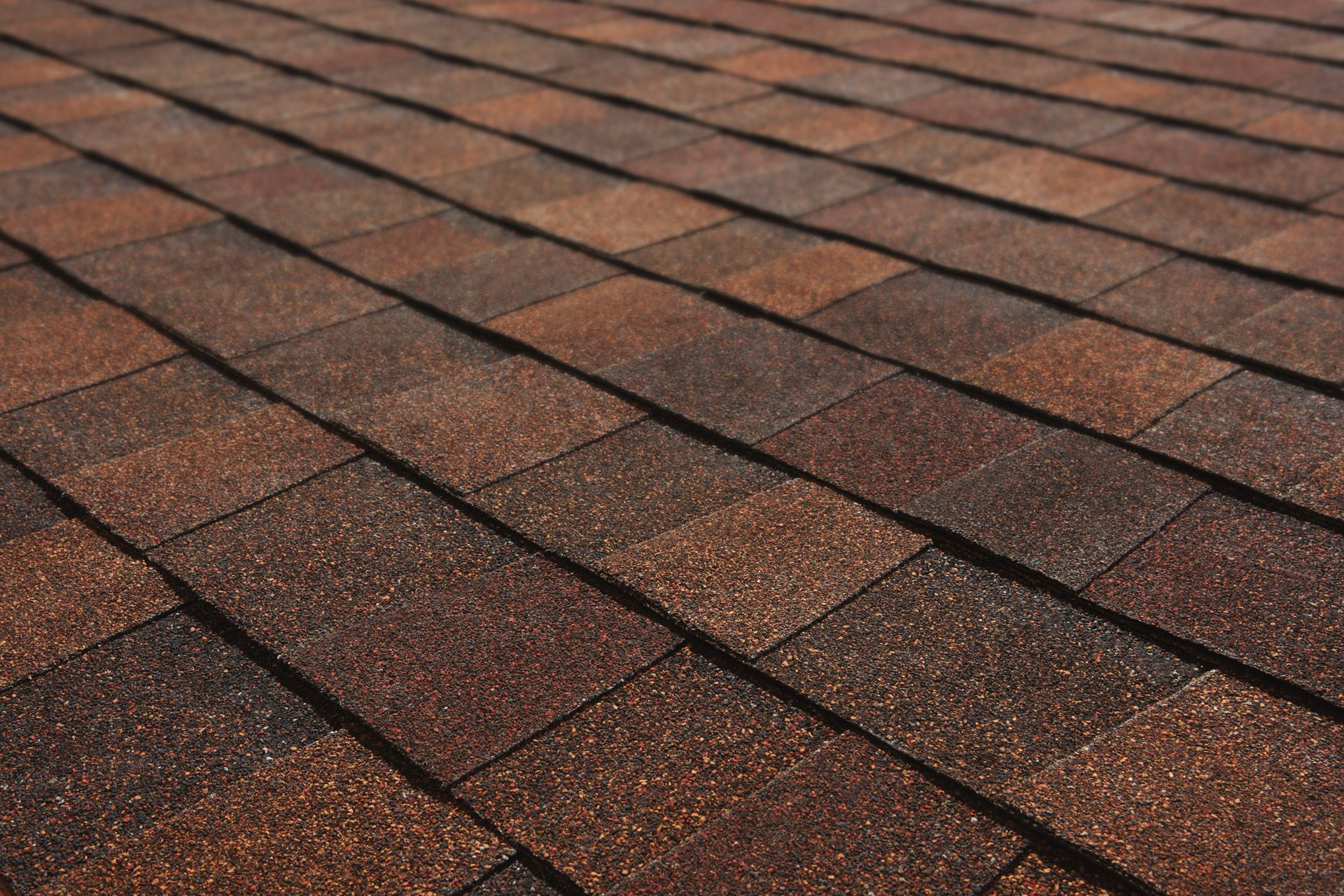 A close up of a roof with brown shingles