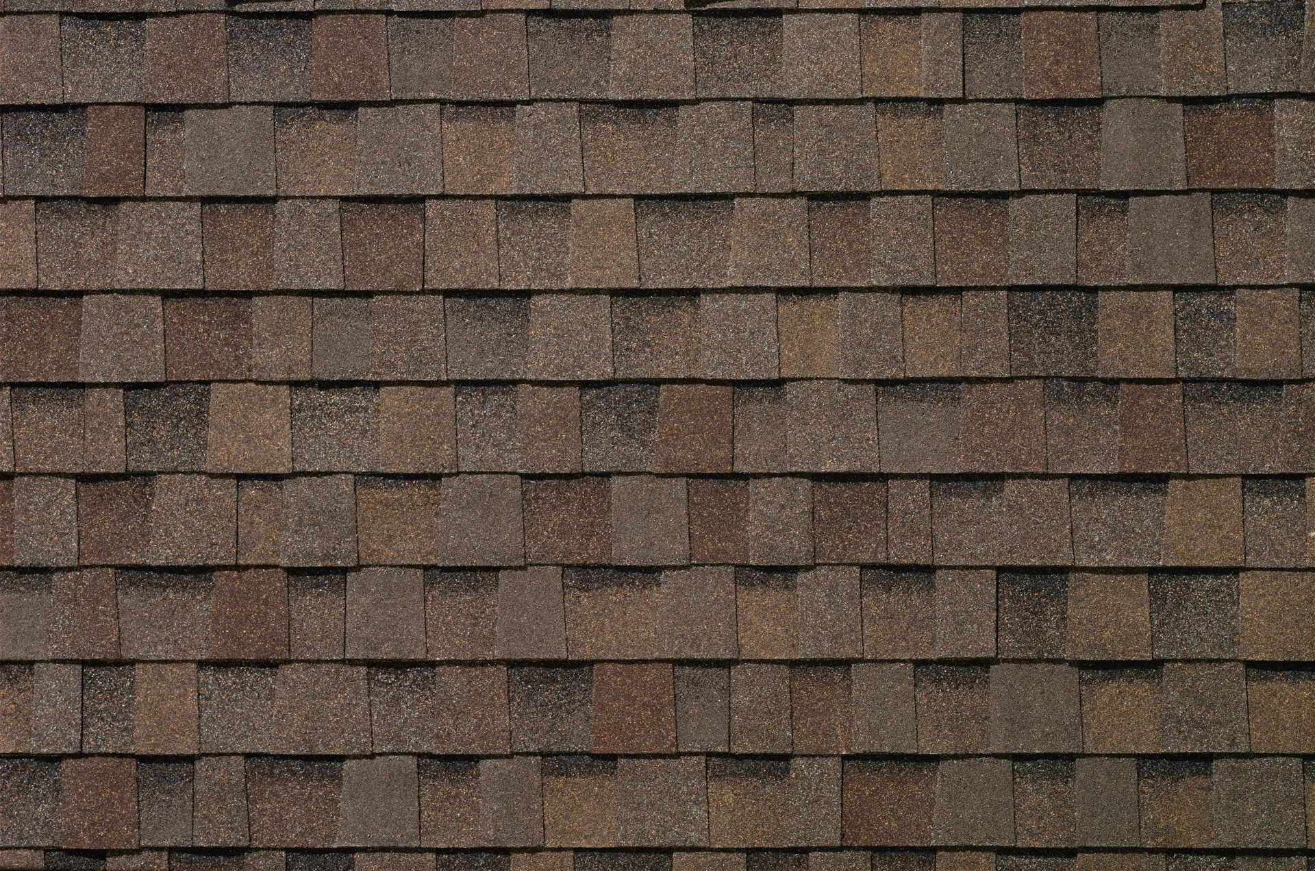 A close up of a roof with brown shingles.