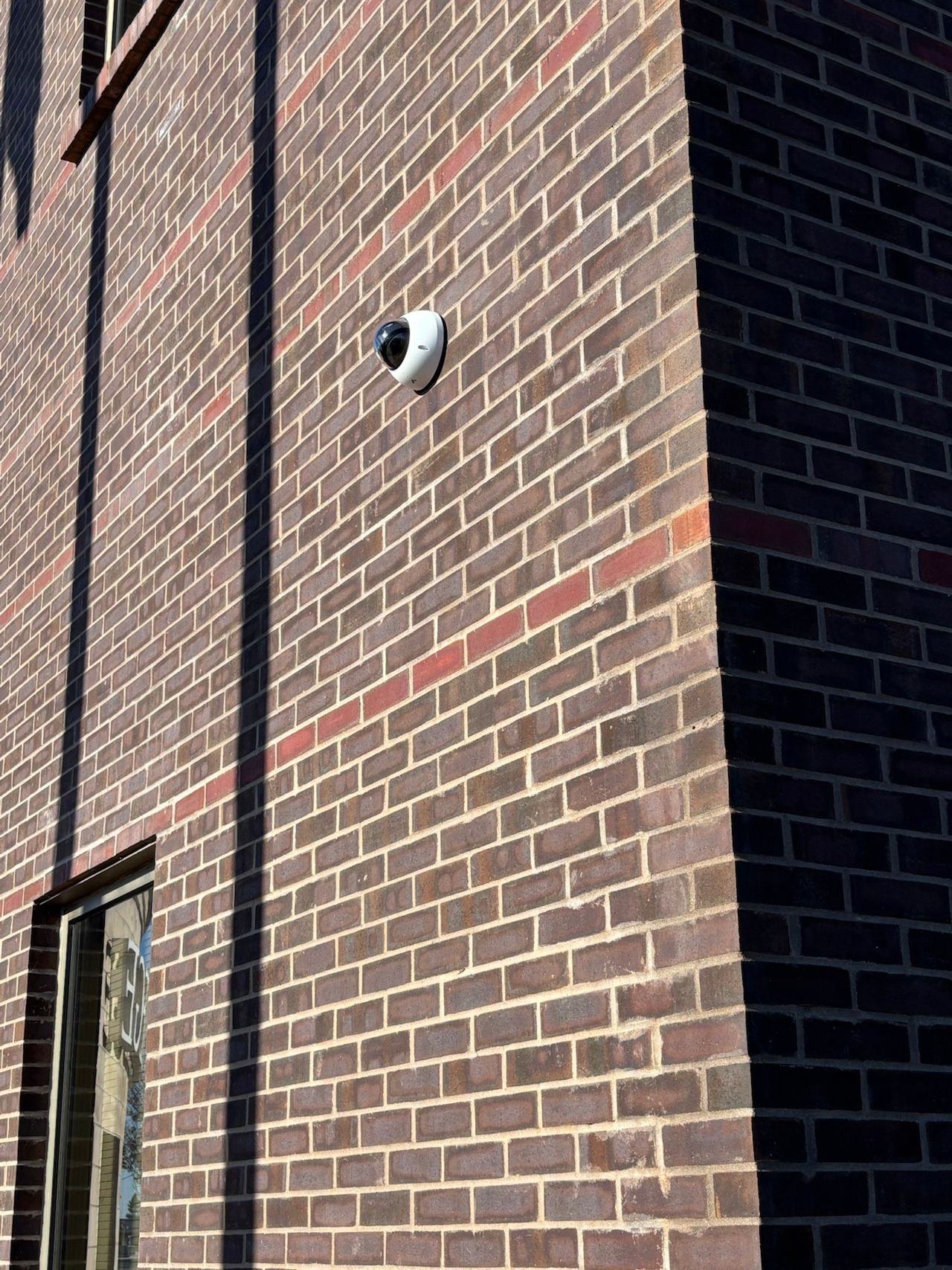 A brick building with a camera on the side of it.