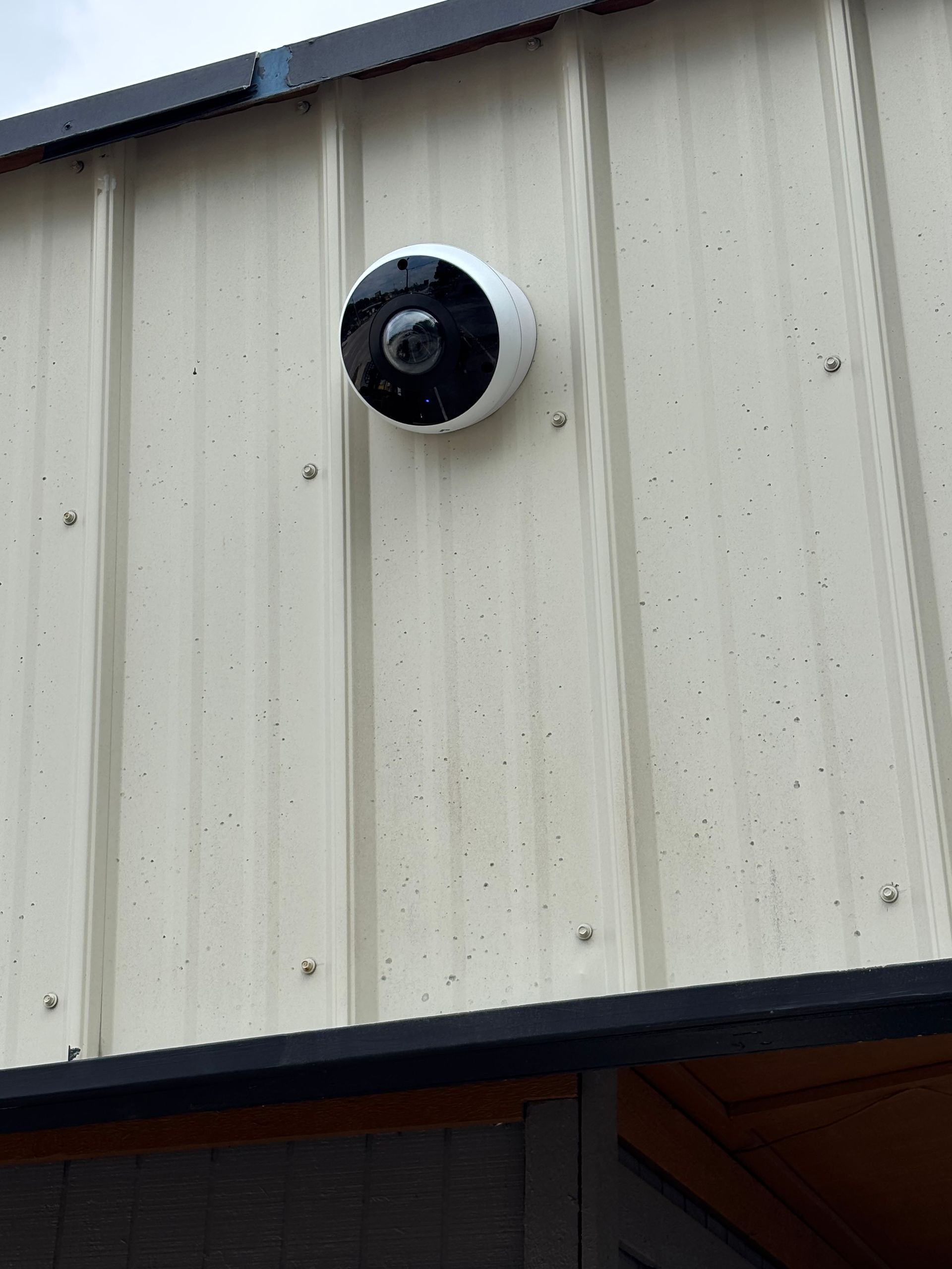 A security camera is mounted on the side of a building.