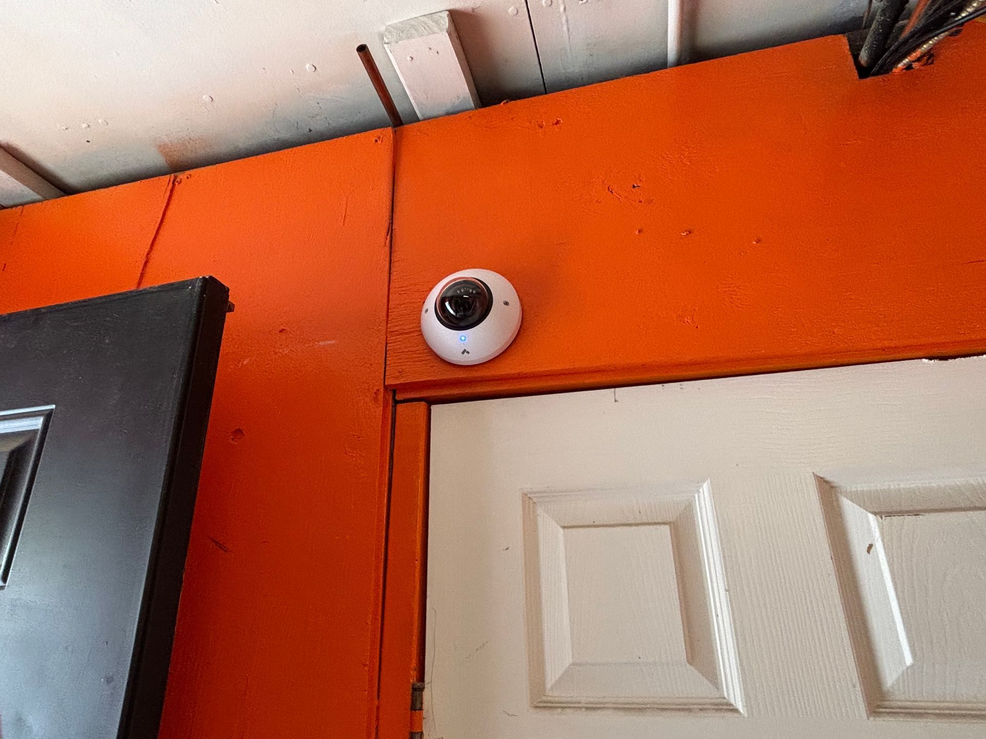 A security camera is mounted on the side of a door.