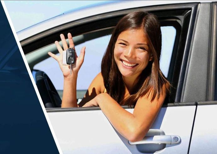 A woman is sitting in a car holding a car key.