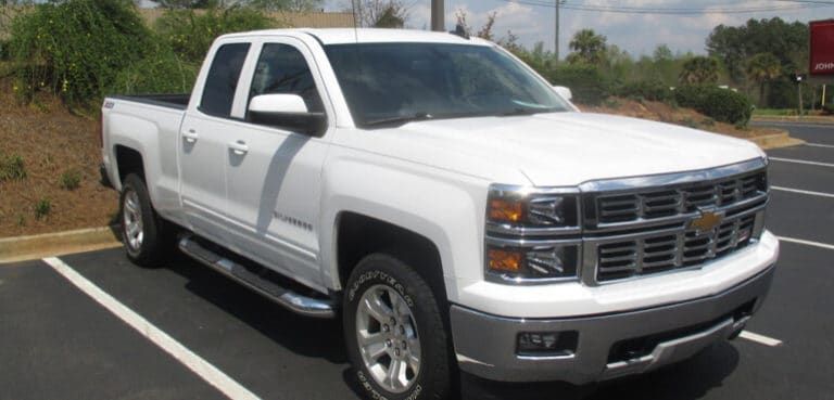 A white truck is parked in a parking lot.