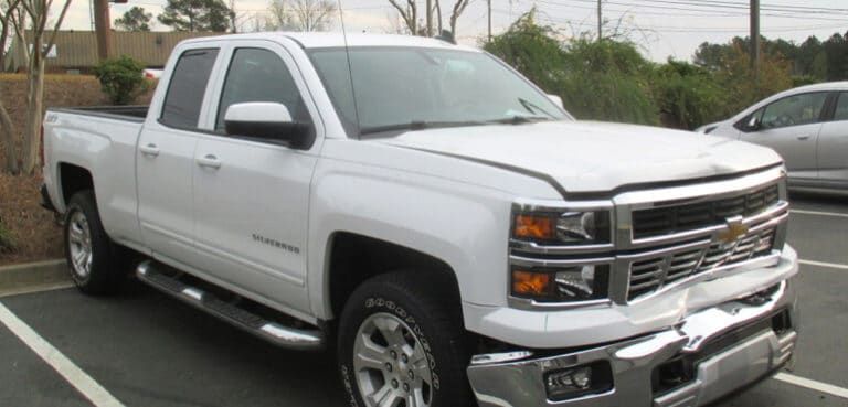 A white pickup truck is parked in a parking lot.