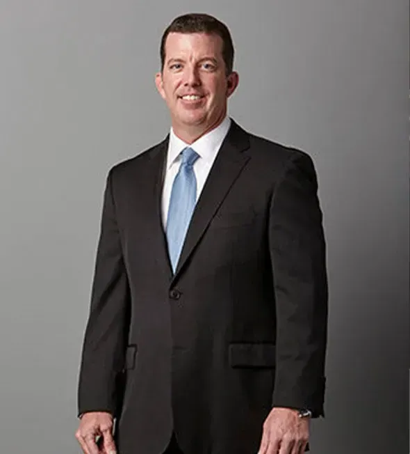 A man in a suit and tie is smiling for the camera