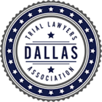 The dallas trial lawyers association logo is a blue and white circle with stars around it.