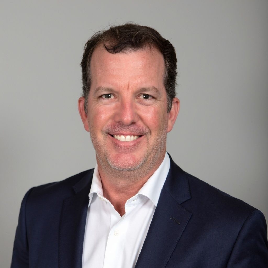 A man in a suit and tie is smiling for the camera