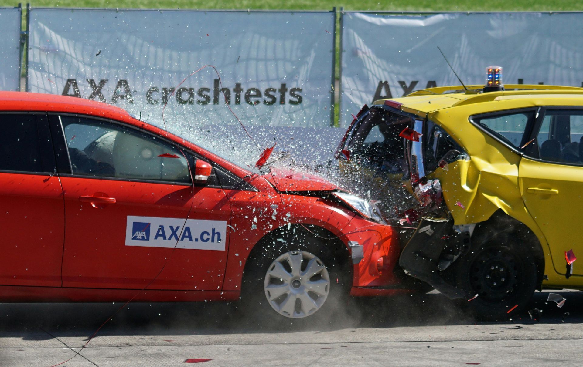 A red car and a yellow car are crashed into each other.