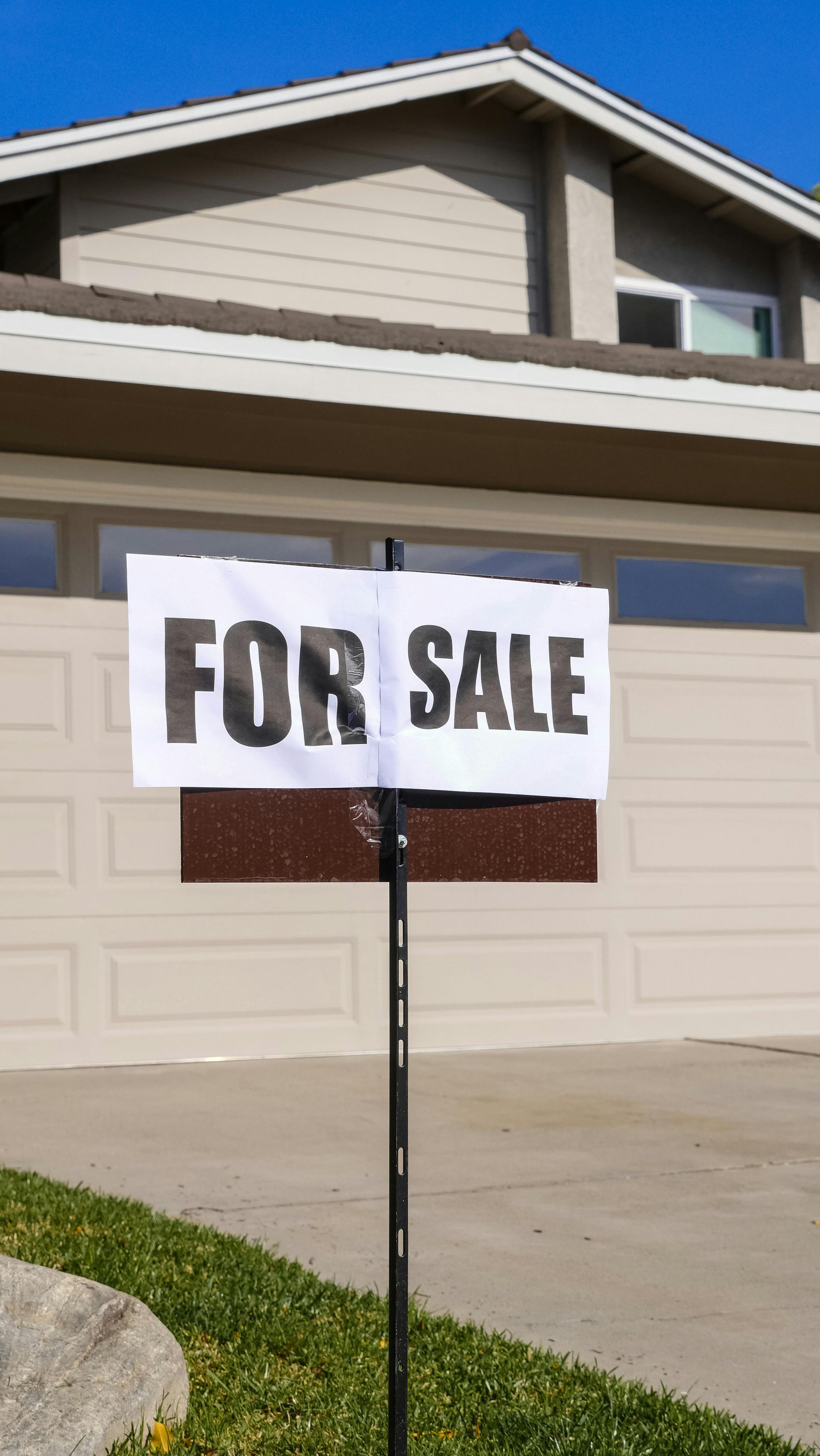 A for sale sign is in front of a house.