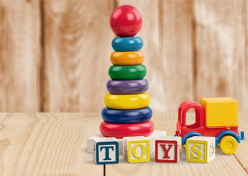 Una mesa de madera cubierta con juguetes y una pila de anillos.