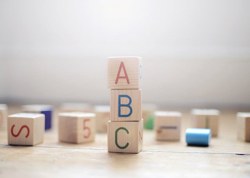 Una pila de bloques de madera con las letras a, b, c y s en ellos.