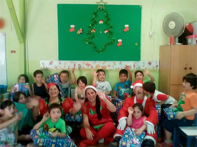 Un grupo de niños posan para una foto frente a un árbol de Navidad.