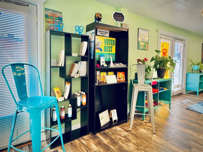 A living room with a bookshelf filled with books and a blue chair.