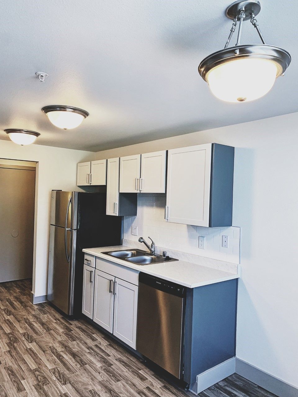 A kitchen with stainless steel appliances and wooden floors