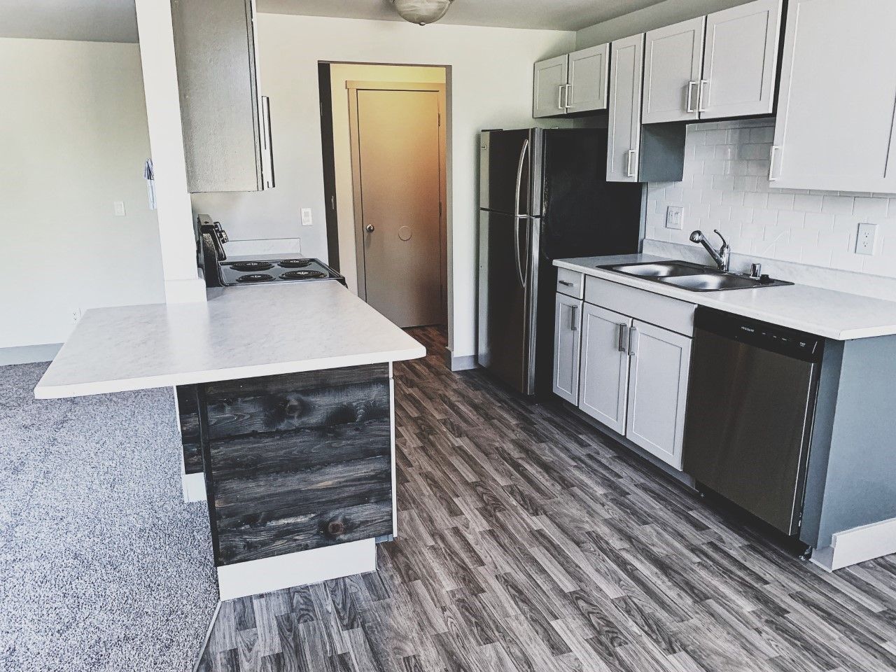 A kitchen with white cabinets and stainless steel appliances