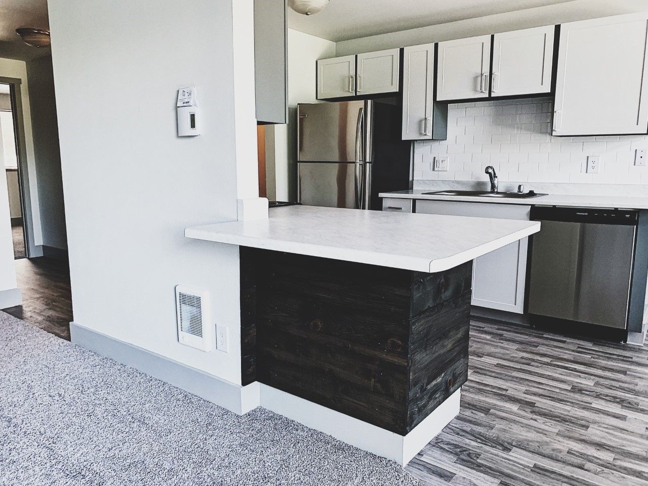 A kitchen with white cabinets and stainless steel appliances