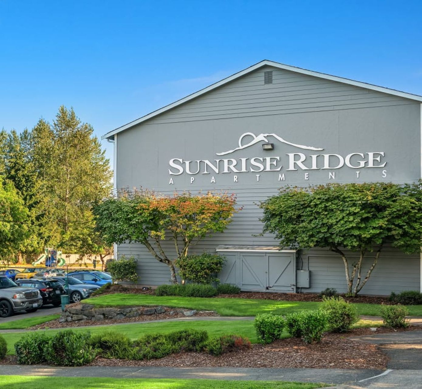 A large building with a sign on the side that says sunrise ridge apartments.