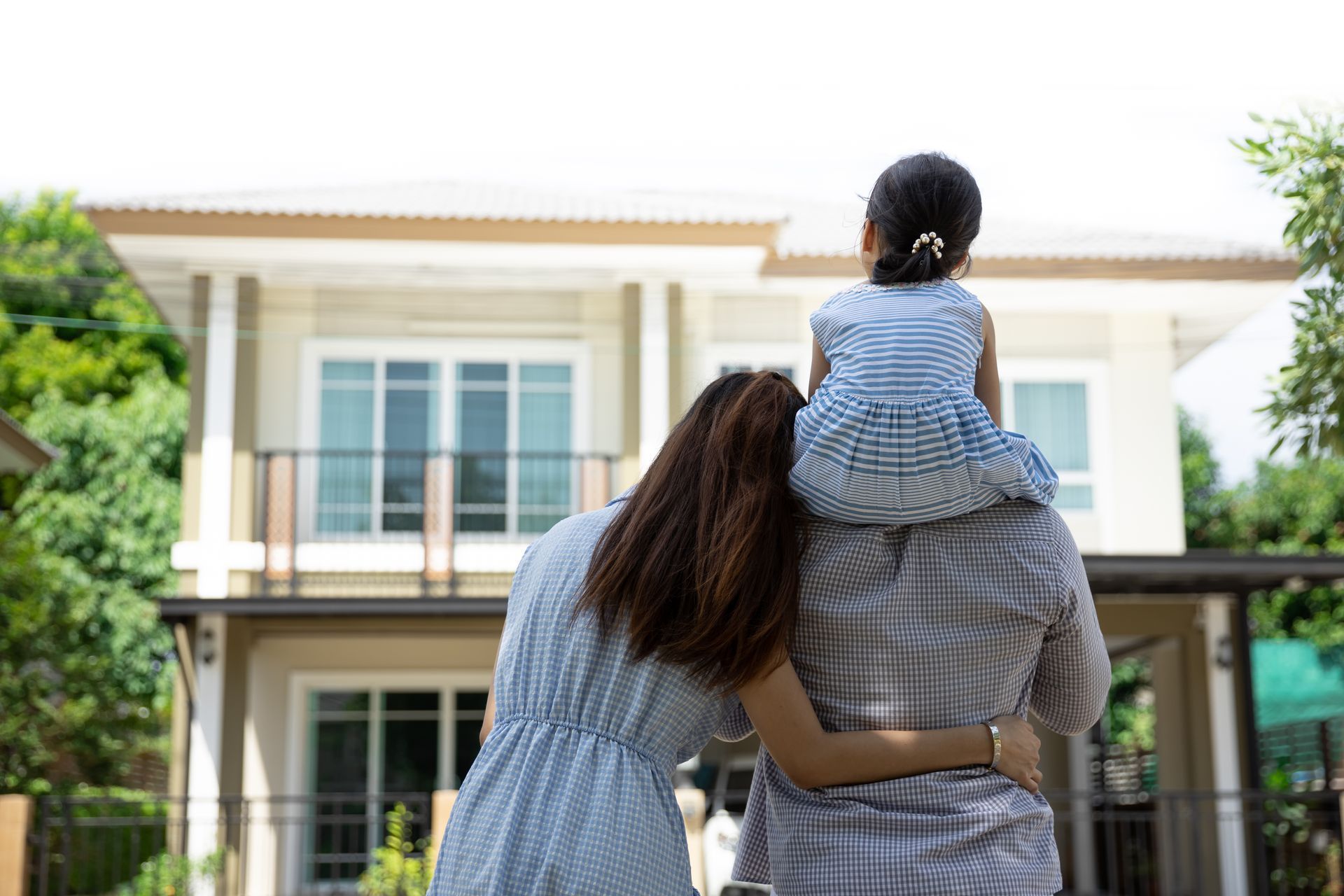 Father, mother and daughter near new home.