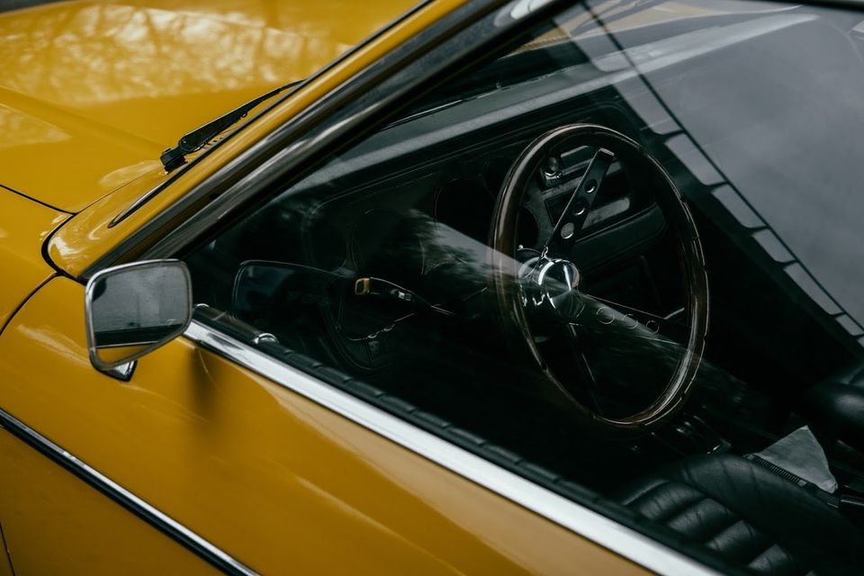 Close-up View of Steering Wheel of Yellow Retro Automobile — Walnut, CA — Coastcomp Insurance Agency