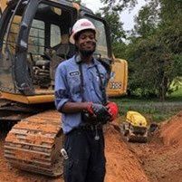 Man in hard hat operating machinery at a construction site.