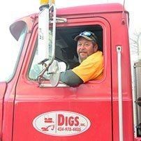 Man in truck cab, wearing cap and yellow shirt, smiling. Red truck with 