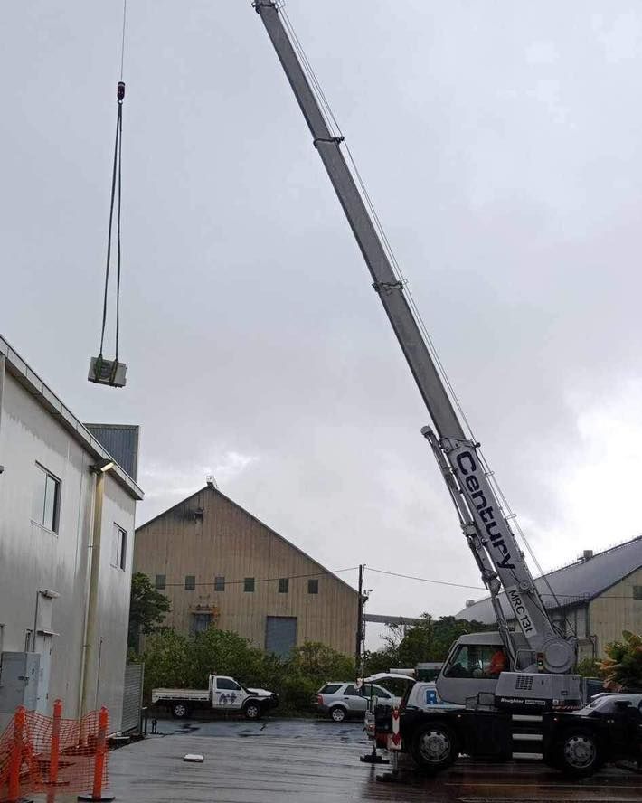 A Century Crane Is Lifting a Large Object — Recharged Air & Electrical in Stratford, QLD