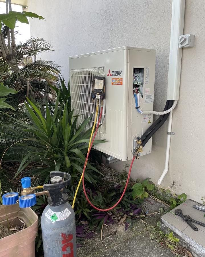 A Gas Cylinder Is Attached to An Air Conditioner Outside of A Building — Recharged Air & Electrical in Stratford, QLD