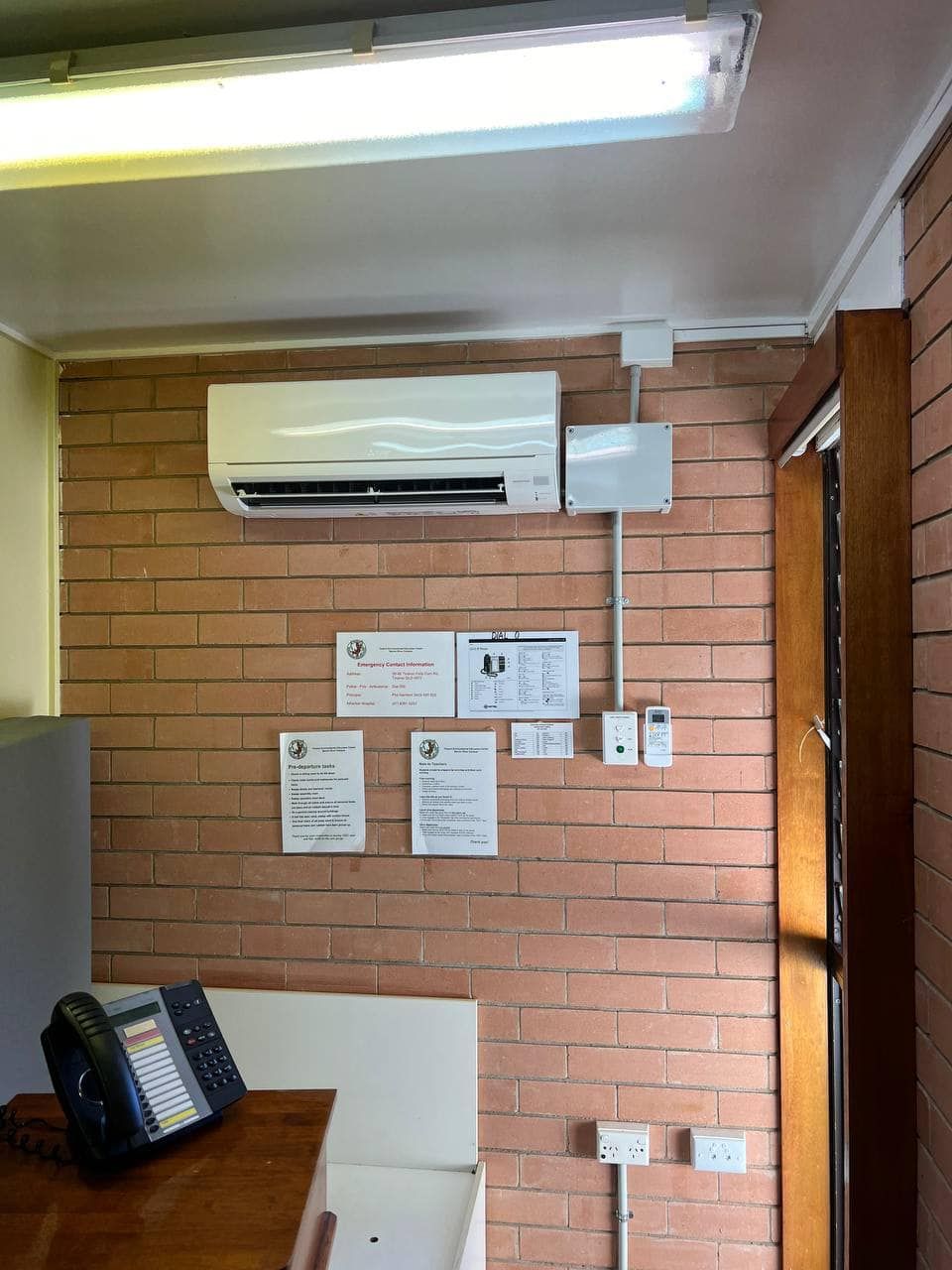 A Room with A Brick Wall and A Telephone on A Table — Recharged Air & Electrical in Stratford, QLD