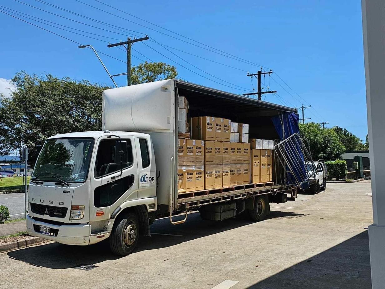A White Truck Is Parked in A Parking Lot Filled with Boxes — Recharged Air & Electrical in Mareeba, QLD