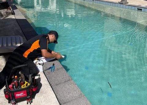 A Group of Men Are Working on A Machine in A Garage — Recharged Air & Electrical in Stratford, QLD