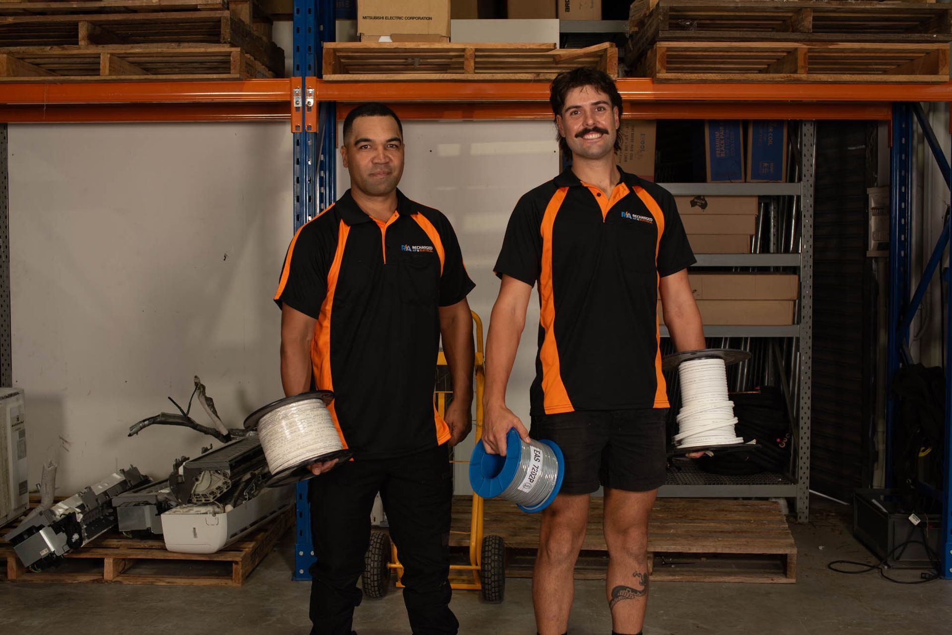 A Group of Men Are Working on A Machine in A Garage — Recharged Air & Electrical in Stratford, QLD