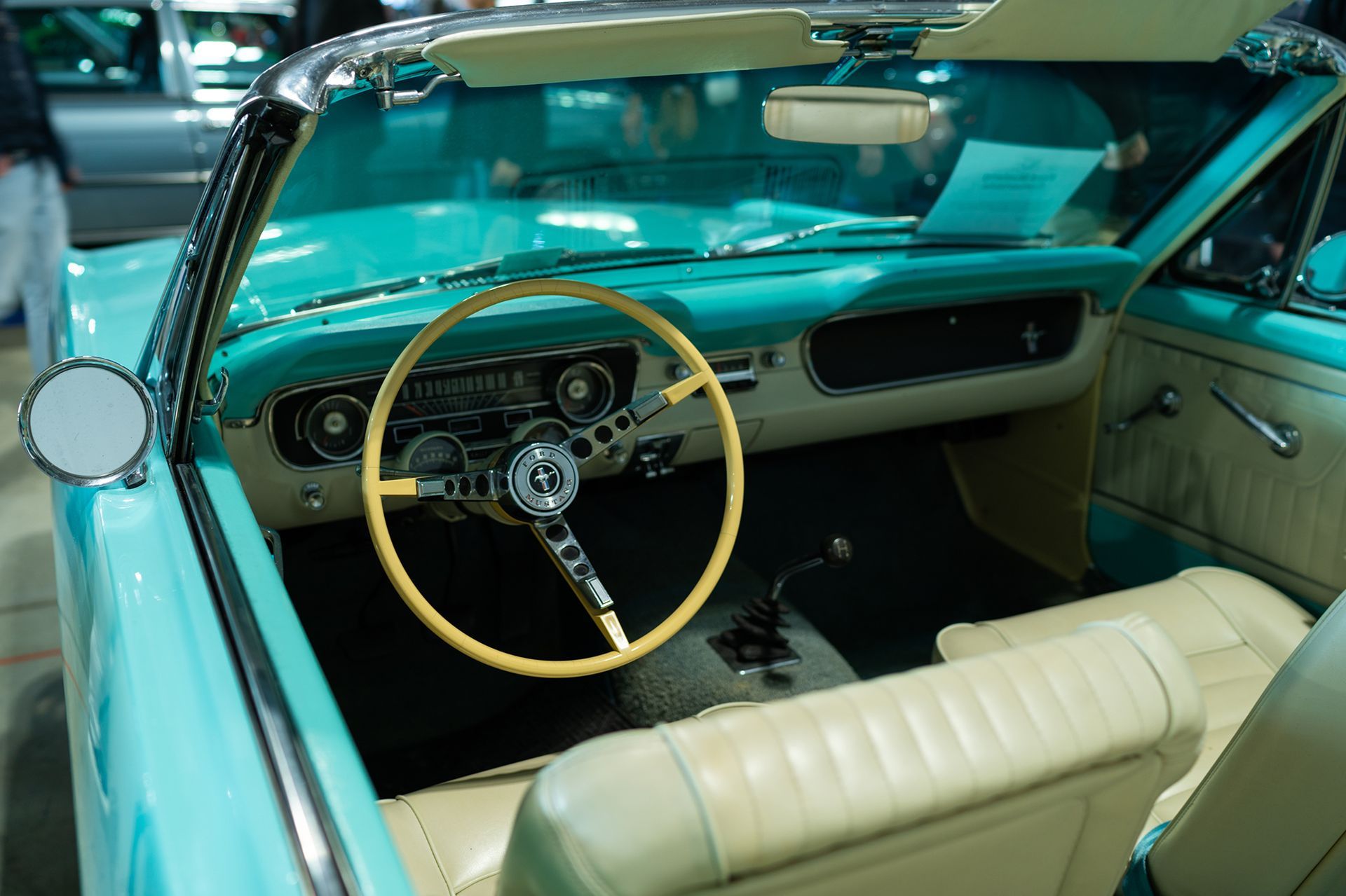 Teal convertible car interior with tan seats and steering wheel, chrome accents.