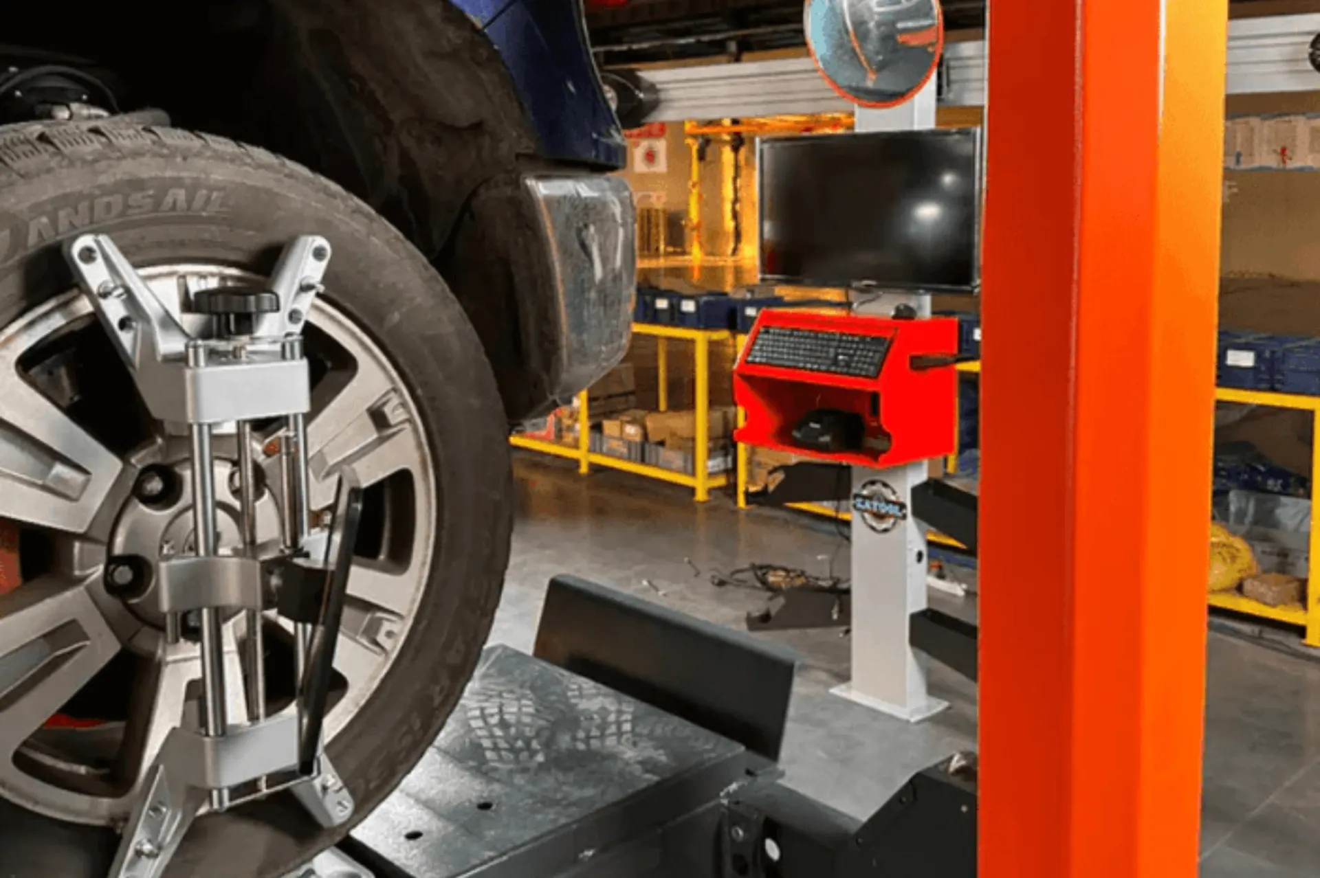 Wheel alignment machine on a car tire, in a mechanic's shop.