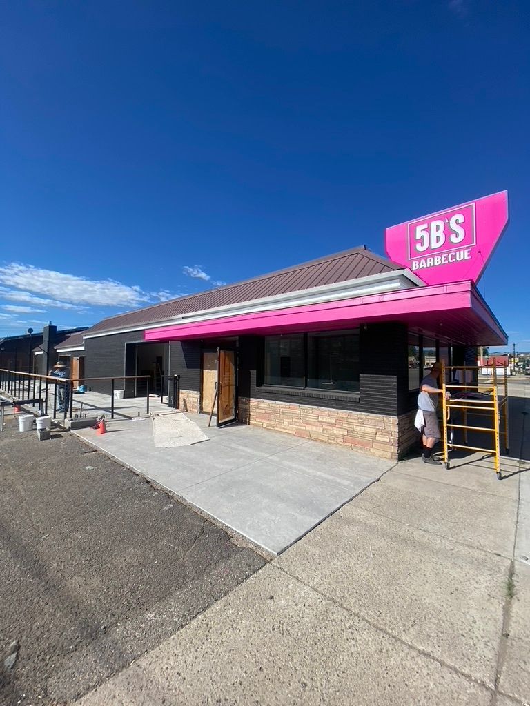 A building with a pink awning is being remodeled.