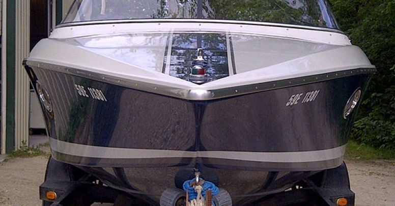 A black and white boat is parked in front of a building.