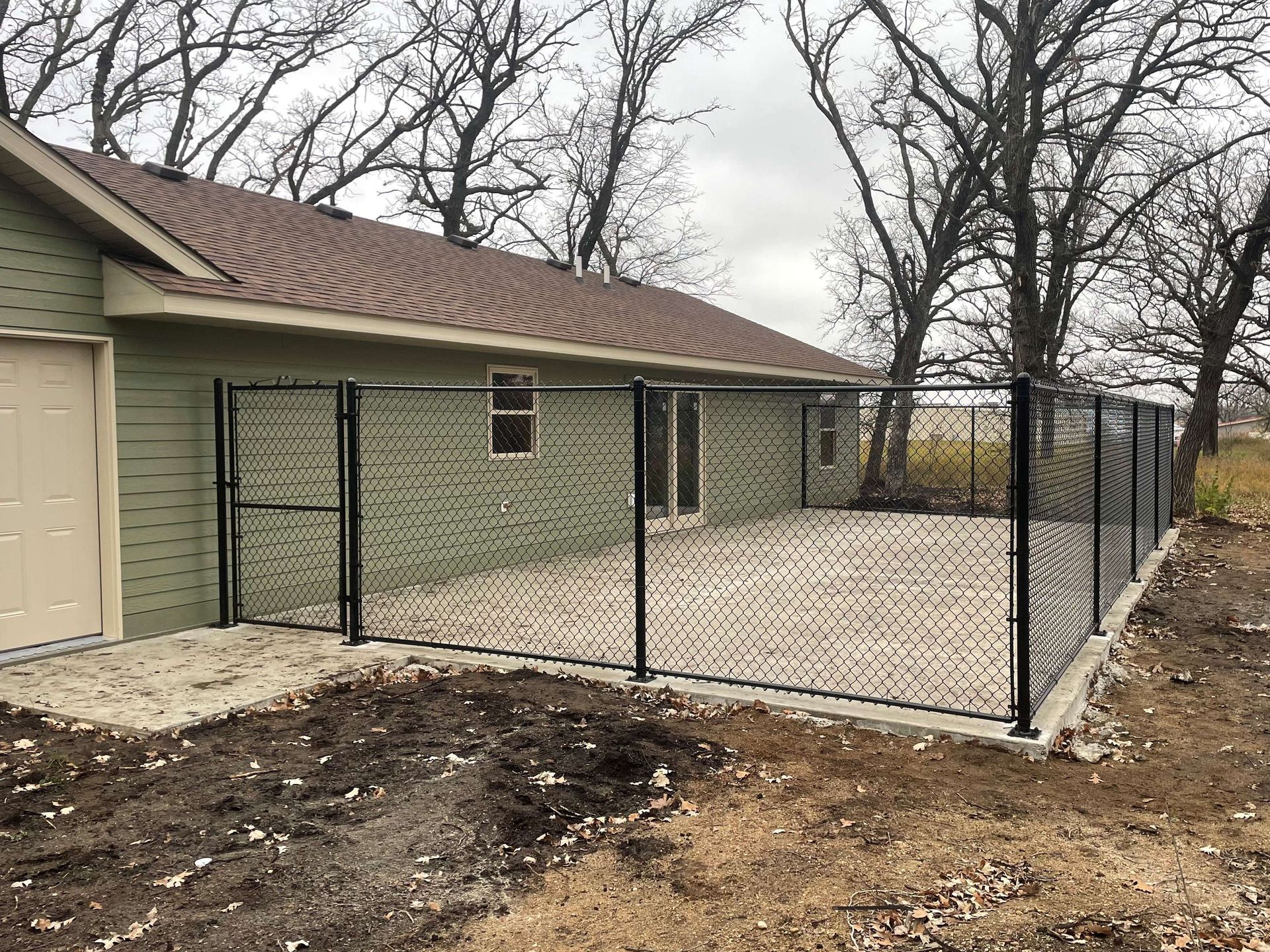 A house with a chain link fence in front of it.