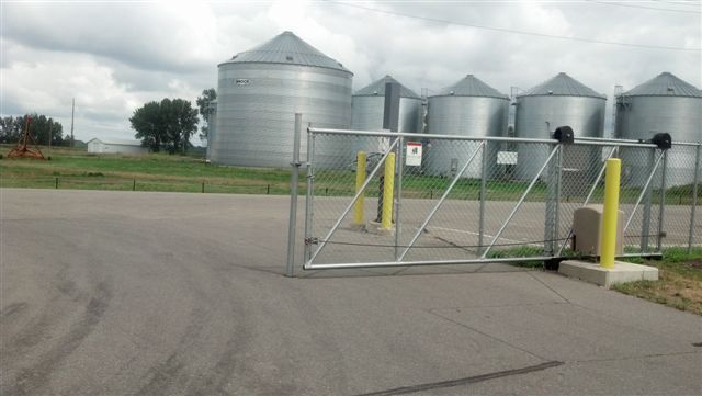 A fenced in area with a lot of silos in the background