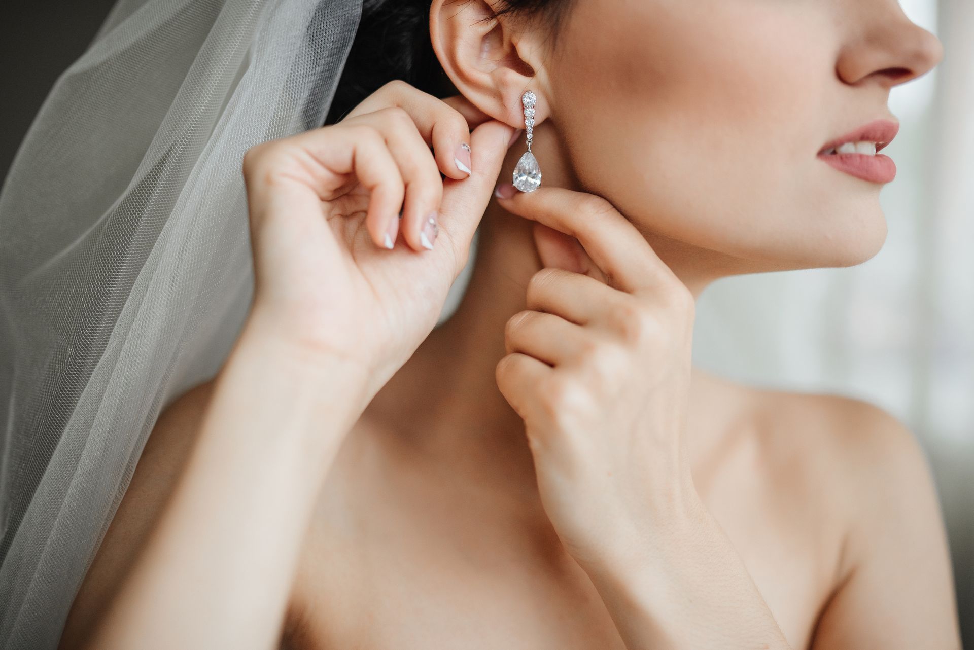 Close-up of a bridal wearing earrings before wedding, highlighting bridal jewelry.