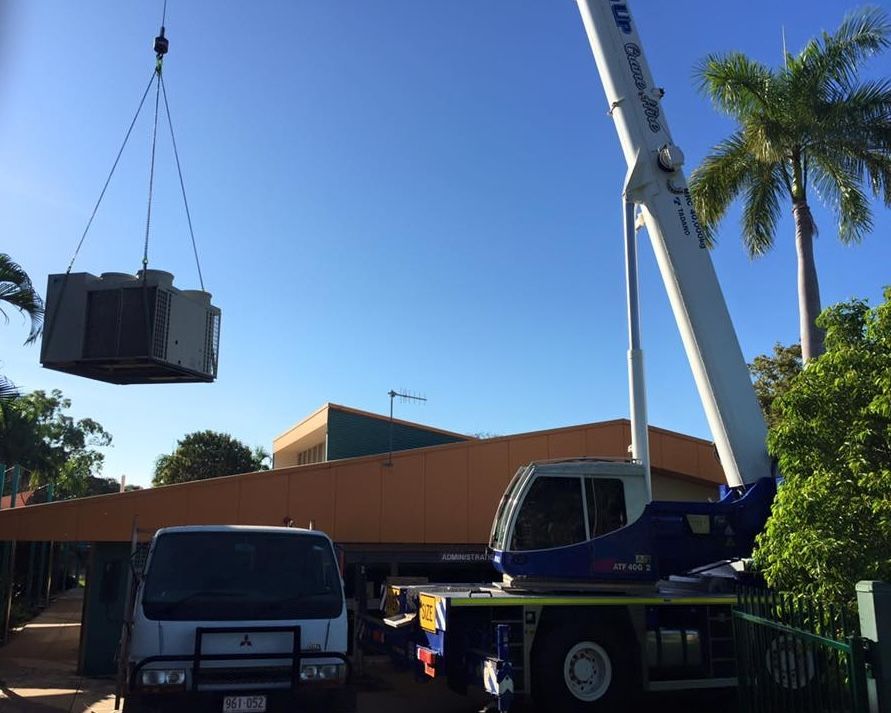 A Crane Is Lifting a Crane Above A Truck — The Cool Guys In Holtze, NT