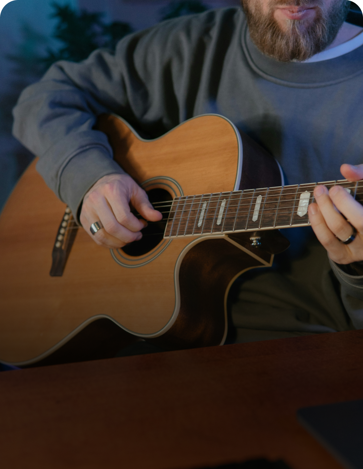 A man with a beard is playing an acoustic guitar