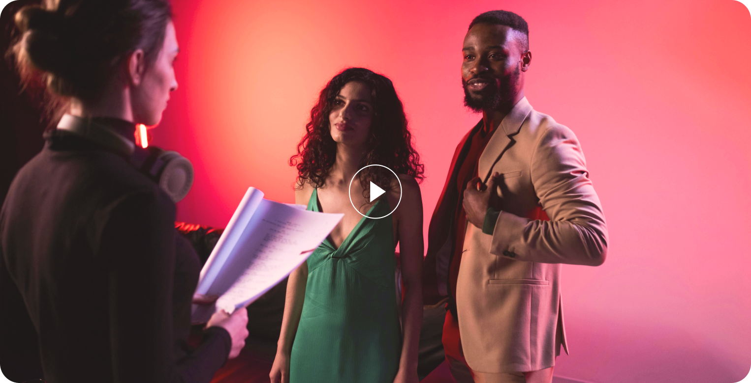 A man and a woman are standing next to each other in front of a red background.