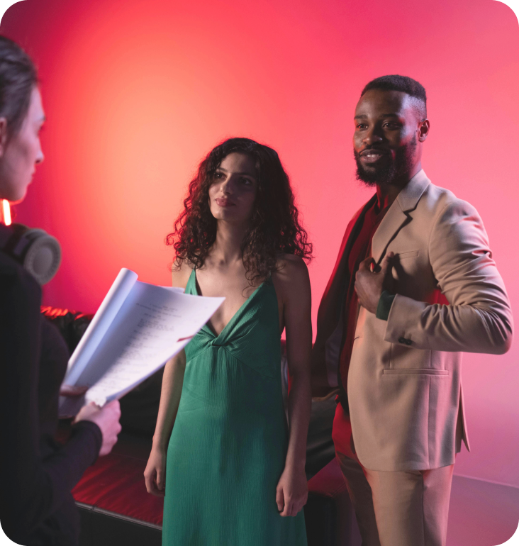 A man in a suit and a woman in a green dress are standing next to each other