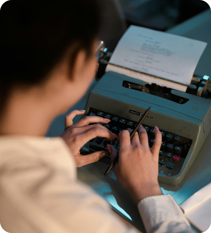 A person is typing on an old fashioned typewriter