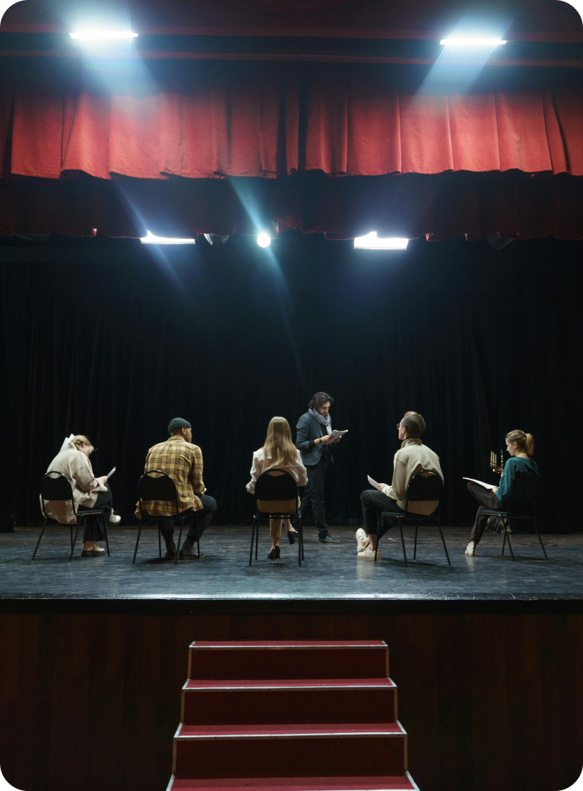 A group of people are sitting in a circle on a stage.