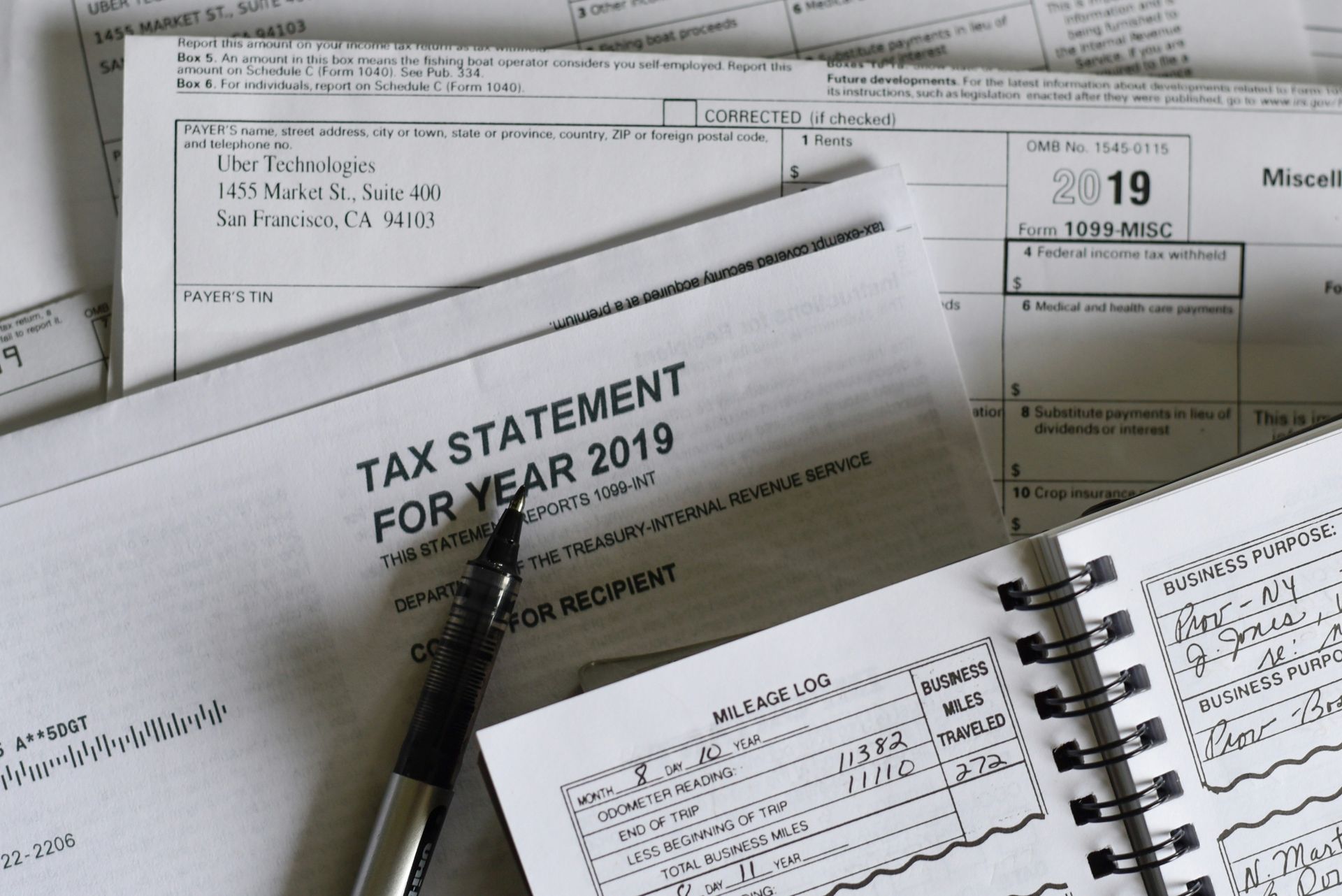 Tax documents including a tax statement, forms, and a notebook with notes.