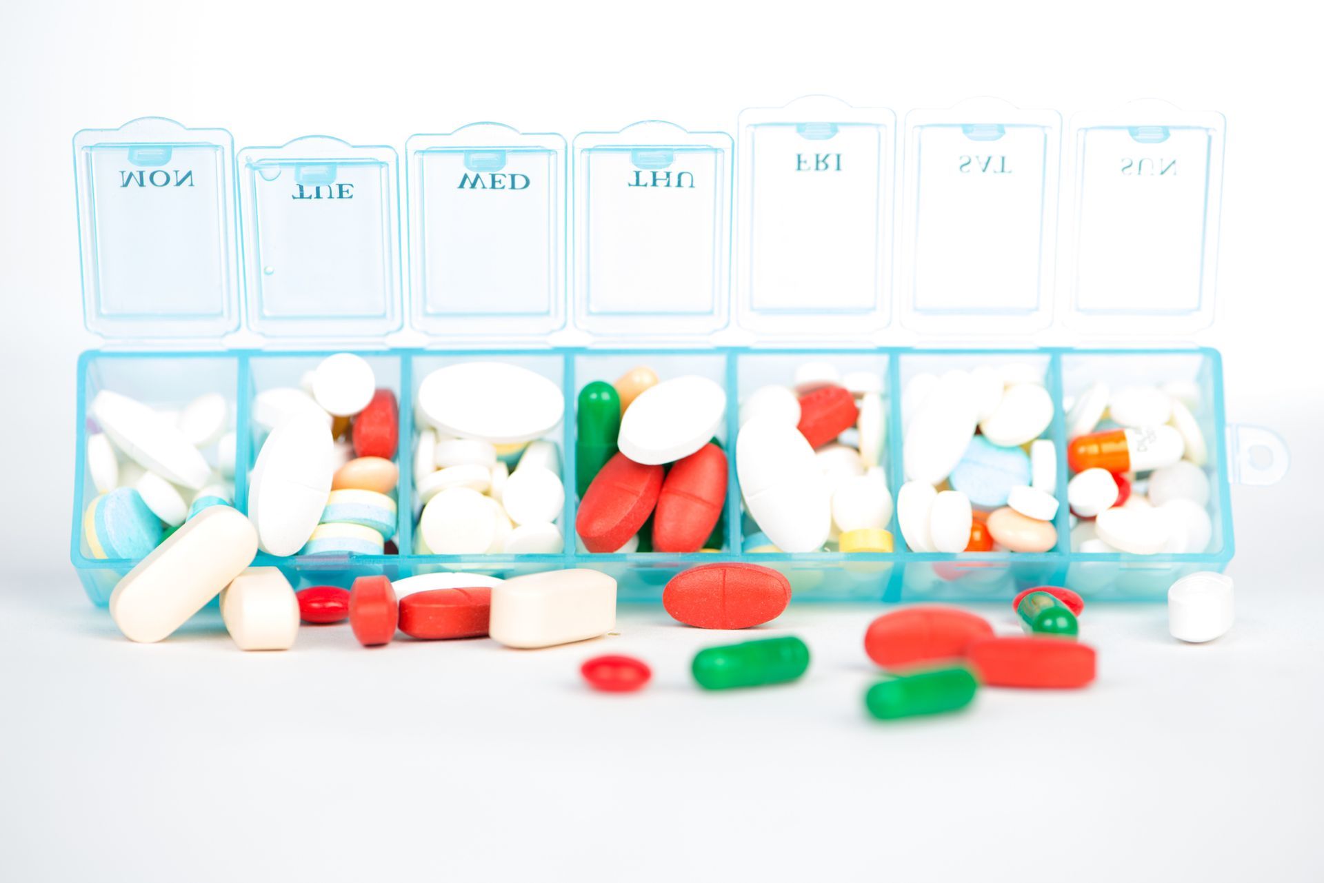 A box filled with pills and capsules on a white background.