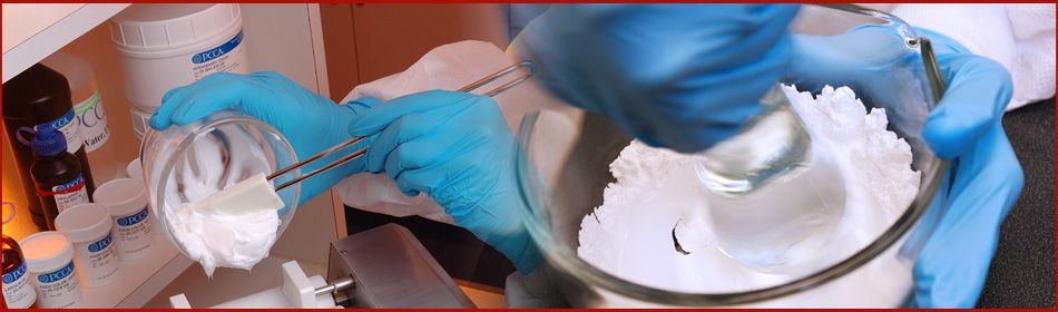 A person wearing blue gloves is mixing something in a bowl.