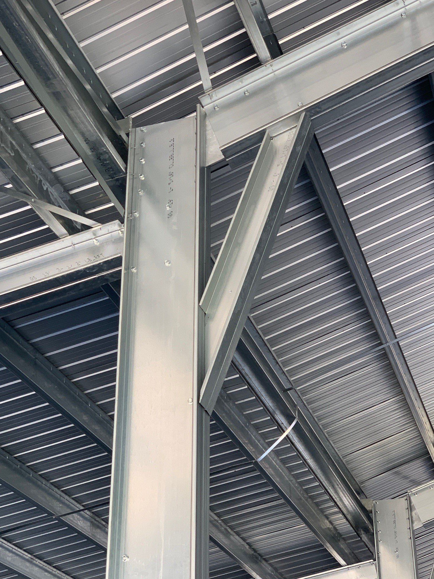 Steel beams and support structures of a building under construction; gray and silver.