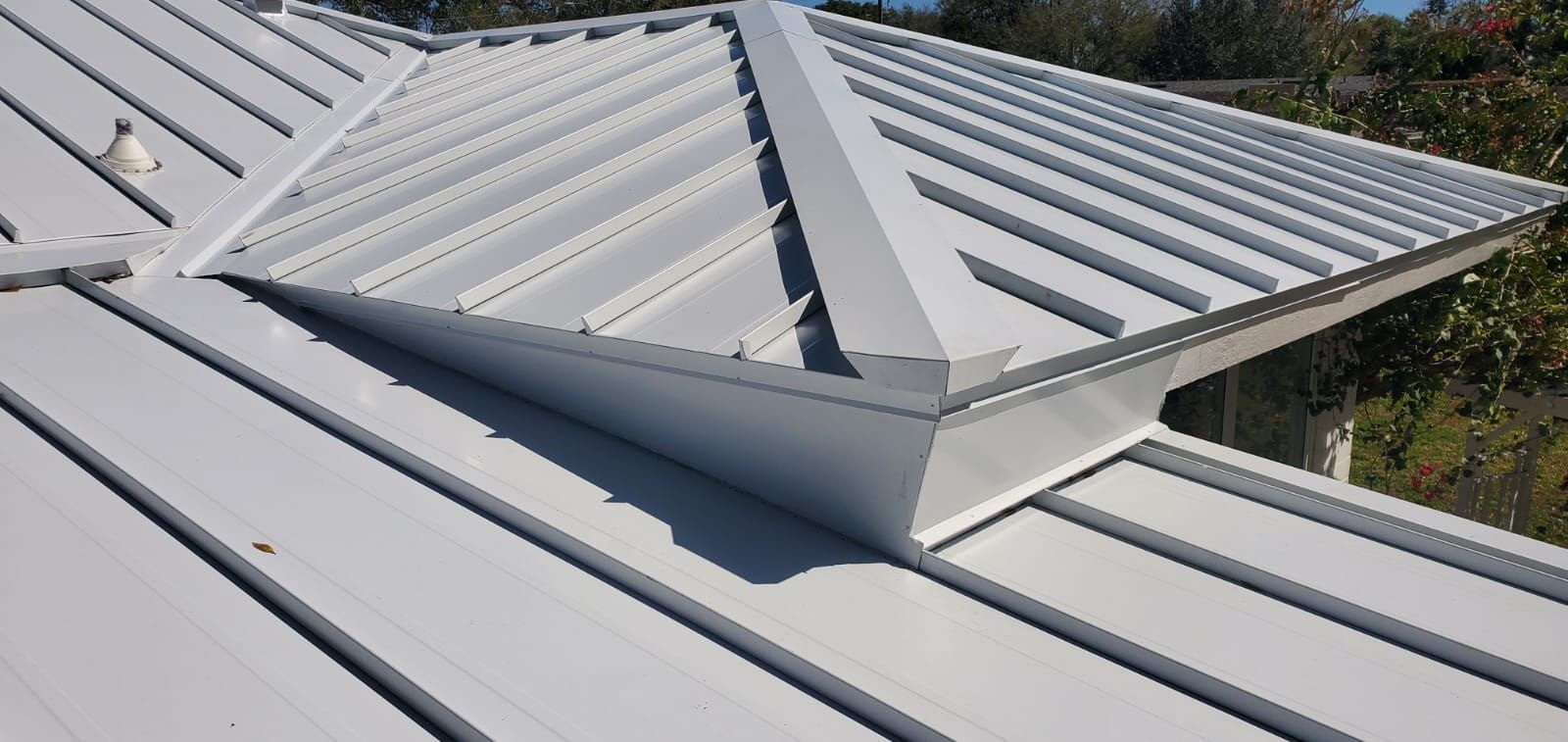White metal roof with a raised triangular structure.
